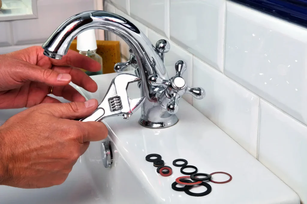 Plumber performing maintenance on a bathroom faucet in Deerfield Beach
