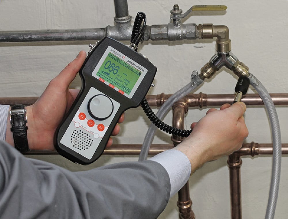 Plumber testing pipes with electronic leak detection equipment in Deerfield Beach