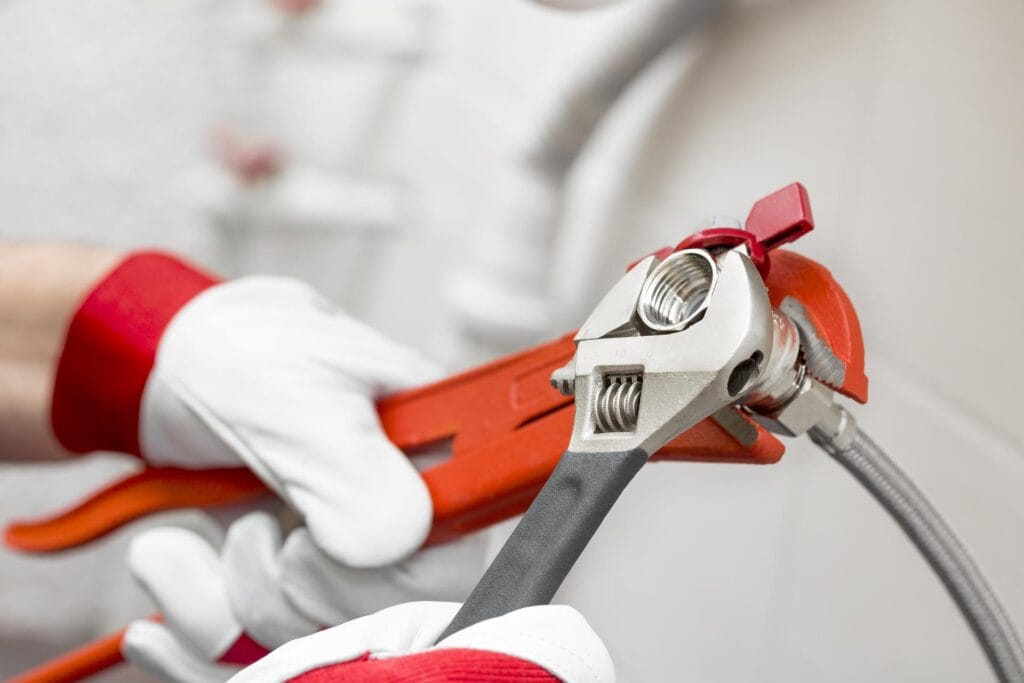 Plumber holding pipe wrenches for an emergency repair in Deerfield Beach