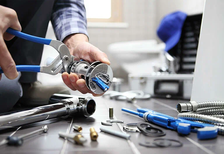 Technician repairing a plumbing fixture with professional tools in Deerfield Beach
