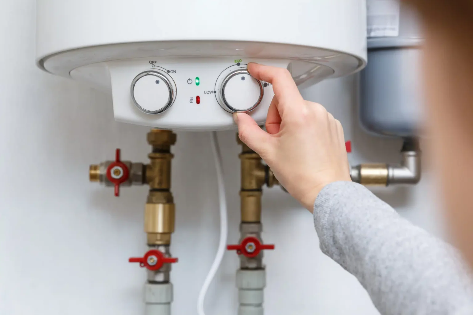 Homeowner adjusting the temperature controls on a water heater in Deerfield Beach