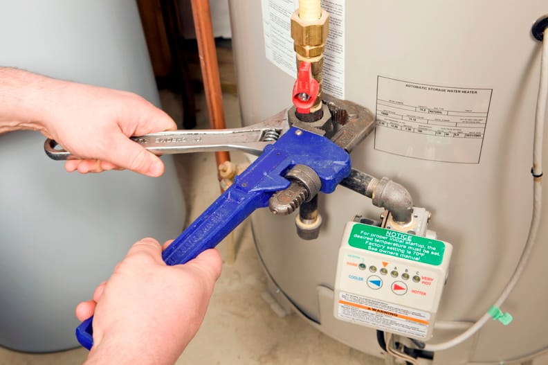 Plumber repairing a water heater valve in Deerfield Beach